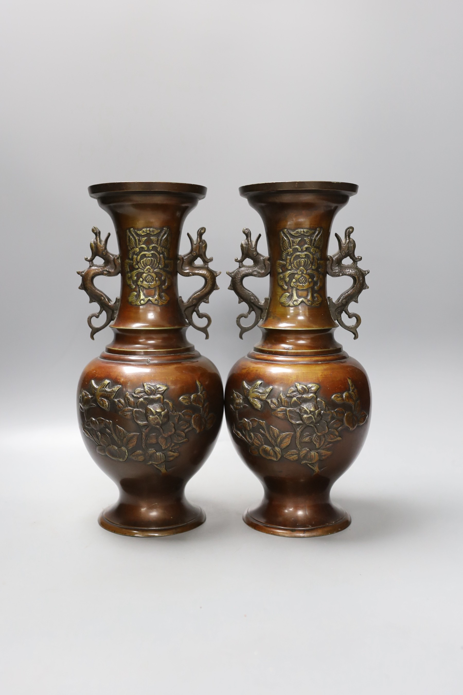 A pair of bronze Japanese vases, a Chinese pewter vase and a ‘lion’ dish 31cm